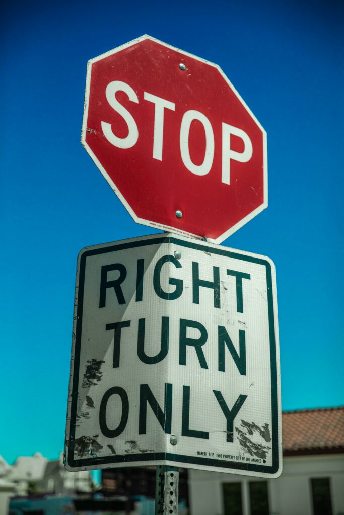 Red stop sign, with a right turn only underneath with a blue sky in the background